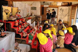 江戸時代の紙雛や明治の土雛などが並んだ雛飾り展を訪れた幼稚園児